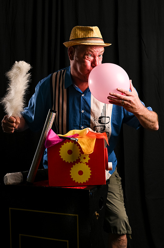 Children's magician bath Somerset, Matt Batstone from Matts Magic blowing up pink balloon